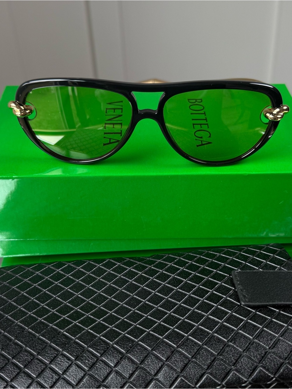 Bottega Veneta Black Frame Sunglasses with Green Lenses and Gold Knots